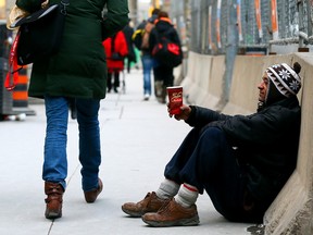 Homeless man James looks for change along Bay St. in Toronto on Sunday, January 25, 2015. (Dave Abel/Toronto Sun)
