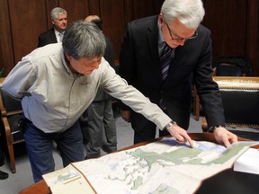 Pimachiowin Aki UNESCO site spokesman William Young (left) shows a map of the site to Manitoba Premier Greg Selinger on Monday. (Brian Donogh/Winnipeg Sun)