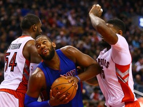 Raptors Patrick Patterson (left) and Amir Johnson guard against Greg Monroe of the Detroit Pistons on Sunday at the ACC. (Dave Abel/Toronto Sun)