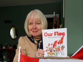 Ann-Maureen Owens shows off a children's book she co-authored with Jane Yealland about the Canadian flag. (Ian MacAlpine/The Whig-Standard)