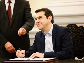 Alexis Tsipras, Syriza party leader and winner of the Greek parliamentary elections, signs papers appointing him as Greece's first leftist prime minister after his swearing-in ceremony at the presidential palace in Athens January 26, 2015. REUTERS/Yannis Behrakis