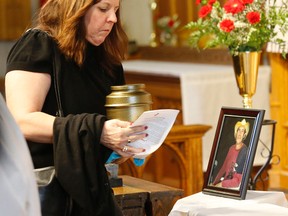 Stacey Fitzpatrick reaches for the  cremation urn of her brother at the funeral of Grant "Gunner" Faulkner at St Timothy's Church in Scarborough on Monday January 26, 2015. (Michael Peake/Toronto Sun)