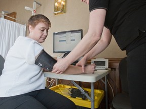 Registered practical nurse Karen MacDonald checks the blood pressure of Leigh-Ann MacKenzie Monday during the Ontario Health Study at the Lamplighter Inn. (DEREK RUTTAN, The London Free Press)