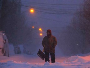 A man with a snow shovel stands in the middle of a snow covered street during a large winter blizzard in Somerville, Massachusetts January 27, 2015.    REUTERS/Brian Snyder