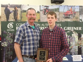 Cole Robbins of Courtright is Lambton County's regional winner of the Ontario Forage Masters' Competition. Presenting him with a plague at the annual meeting of the Lambton Soil and Crop Improvement Association, at left, is provincial director Chad Anderson.