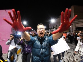 A demonstrator holds up his hands covered in red paint while yelling slogans in support of the 43 missing trainee teachers of the Ayotzinapa teachers' training college, during a protest at the International Santa Fe bridge and border crossing between Mexico and the U.S. in Ciudad Juarez January 26, 2015. The 43 students went missing on September 26, 2014 in Iguala, a city in the poor southwestern state of Guerrero. The government says the students were abducted by corrupt police working for a local drug cartel, which it said incinerated their bodies at a nearby garbage dump.  REUTERS/Jose Luis Gonzalez