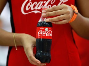 A promotion lady holds a Coca-Cola bottle on July 27, 2013. REUTERS/Soe Zeya Tun/Files