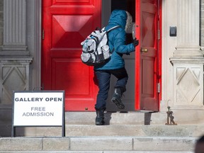 A woman opens the iconic red front door to the McIntosh Gallery on the Western University campus. A new study says the school is worth billions to its host city. (Craig Glover, The London Free Press)
