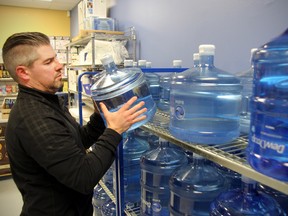Ryan Litton, owner of the World of Water store on Goulet Street in Winnipeg, Man., stocks shelves in his store Tuesday Jan. 27, 2015 after the city put out a precautionary boil water advisory due to possible e-coli contamination.