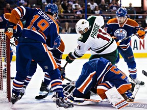 Oilers goalie Viktor Fasth goes down as Minnesota forward Zach Parise attacks the net during first-period action Tuesday at Rexall Place. (Codie McLachlan, Edmonton Sun)