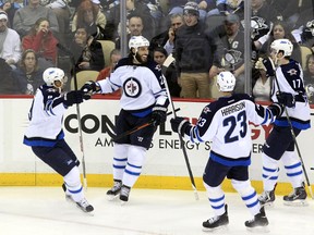 Jan 27, 2015; Pittsburgh, PA, USA; Winnipeg Jets right wing Chris Thorburn (22) is congratulated by left wing Evander Kane (left) and defenseman Jay Harrison (23) and left wing Adam Lowry (17) after scoring a goal against the Pittsburgh Penguins during the second period at the CONSOL Energy Center. Mandatory Credit: Charles LeClaire-USA TODAY Sports