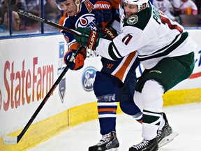 Edmonton’s Mark Fayne (5) is harassed by Minnesota’s Zach Parise (11) during Tuesday’s NHL game at Rexall Place. (Codie McLachlan, Edmonton Sun)