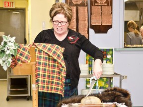 Kim Skidmore reads the traditional Address to a Haggis as she “stabs” the haggis at the Cochrane Royal Canadian Legion during the Holy Trinity Anglican Parish's Robbie Burns Night. Robbie Burns Night is a celebration held around the world close to the poet's Jan 25th birthday to celebrate his life and works.