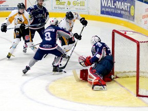 Cochrane Crunch defenceman Max Glashauser keeps Abitibi Eskimos forward Jake Holland from getting solid wood on a close-in shot on Crunch goalie Brett Young during the second period of an NOJHL game at the Jus Jordan Arena in Iroquois Falls Saturday night. The Eskimos went on to post an 8-2 win over the Crunch and pull within three points of their Highway 11 rivals in the East Division standings.