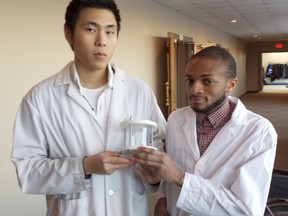 Jung Kyu Tang, left, a graduate researcher, and student Kufre Ibionoh hold one of the pieces of research equipment on display Wednesday at the Lambton College Event Centre during a community breakfast college officials held to provide an update on its strategic plan. Those plans include continuing work in applied research, as well as a $45-million project to build new fitness and health science buildings at the London Road campus. (PAUL MORDEN, The Observer)