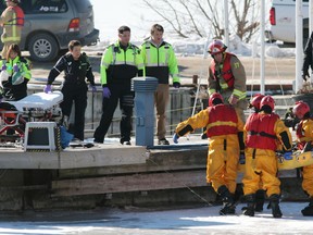 Kingston firefighters carry a man to a dock where Frontenac paramedics wait to treat and transport him to hospital. The man was found on the ice near the yacht club on Wednesday, Jan. 28, 2015 in Kingston.ELLIOT FERGUSON/KINGSTON WHIG-STANDARD/QMI AGENCY