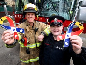 Calgary firefighter, Andrew Levitt and Calgary Police Const. Reid Laurence were on hand as the City of Calgary gave the OK to display decals on their first responding vehicles in November. Darren Makowichuk/QMI Agency