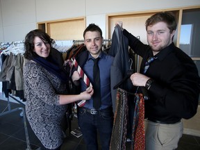Amanda Hulton of St. Lawrence School of Business with students Aaron Francis and Bradley Robertson, with some used clothing being donated to students at the college. (Ian MacAlpine/The Whig-Standard)