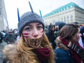 A woman wears a tape with the word 'Liberte' (Freedom) on her mouth during a silent protest for the victims of the shooting at the Paris offices of weekly newspaper Charlie Hebdo, at the Pariser Platz square in Berlin January 11, 2015. REUTERS/Hannibal Hanschke