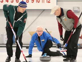 Fred Johnston, left, and Rich Waller, right, of the host Royal Kingston Curling Club prepare to sweep a shot from Cam Gruer during the first day of play at the 82nd Whig-Standard Bonspiel on Thursday. The three are members of skip Larry Waller’s rink, which lost the game to a Toronto team skipped by Steve Small. (Elliot Ferguson/The Whig-Standard)