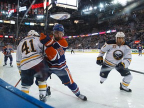 Edmonton forward Luke Gazdic (20) checks Buffalo defenceman Andrej Meszaros (41) during the first period of a NHL hockey game between the Edmonton Oilers and the Buffalo Sabres at Rexall Place in Edmonton, Alta., on Thursday, Jan. 29, 2015. Ian Kucerak/Edmonton Sun/ QMI Agency