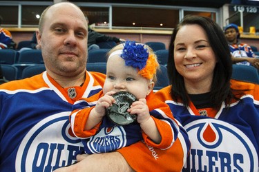 Edmonton fans Larissa and Dennis Kawczak brought their daughter Zoey, 9-months-old, to help cheer at a NHL hockey game between the Edmonton Oilers and the Buffalo Sabres at Rexall Place in Edmonton, Alta., on Thursday, Jan. 29, 2015. Ian Kucerak/Edmonton Sun/ QMI Agency