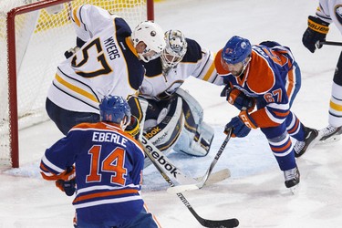 Edmonton forward Benoit Pouliot (67) and Buffalo defenceman Tyler Myers (57) battle in front of goaltender Jhonas Enroth's (1) net during the second period of a NHL hockey game between the Edmonton Oilers and the Buffalo Sabres at Rexall Place in Edmonton, Alta., on Thursday, Jan. 29, 2015. Ian Kucerak/Edmonton Sun/ QMI Agency