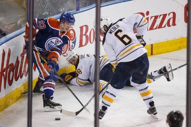 Edmonton centre Ryan Nugent-Hopkins (93) and Buffalo defenceman Mike Weber (6) battle during the second period of a NHL hockey game between the Edmonton Oilers and the Buffalo Sabres at Rexall Place in Edmonton, Alta., on Thursday, Jan. 29, 2015. Ian Kucerak/Edmonton Sun/ QMI Agency