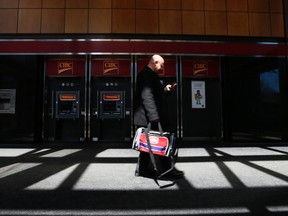 A pedestrian walks past the CIBC ATM machines in  Montreal, April 24, 2014. (REUTERS/Christinne Muschi)