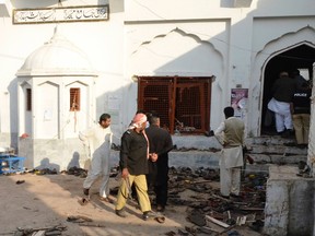 Residents and police stand among victims' shoes after an explosion in a Shi'ite mosque in Shikarpur, located in Pakistan's Sindh province on Jan. 30, 2015. (REUTERS/Amir Hussain)