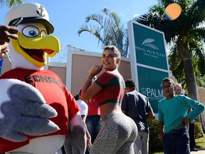 A fan wears a bird costume with the name of Cristiano Ronaldo on the chest poses with Andressa Urach, a Brazilian model and actress who painted her upper body with Portugal's national soccer jersey, while gathering outside Portugal's hotel as the team arrived in Campinas, June 11, 2014. Portugal plays their first match of the 2014 World Cup  on June 16 against Germany.