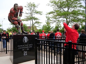 A fan takes a photo of a statue of Chicago Blackhawks legend Stan Mikita prior to Game 2 of the NHL Western Conference Final during the 2013 playoffs at United Center on June 2, 2013 in Chicago. (Jamie Squire/Getty Images/AFP)