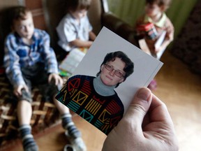 Anatoly Gorlov, husband of Russian activist Svetlana Davydova, holds up a photo of her, as their children are seen in the background, at their home in Vyazma, January 30, 2015. Nine months after Davydova called the Ukrainian embassy in Moscow to warn that Russian soldiers were making their way to Ukraine, an investigator with an order for her arrest showed up at her door. Gorlov said the investigator from the Federal Security Service (FSB), the successor to the Soviet KGB, detained Davydova, a mother of seven living in the western Russian city of Vyazma, on suspicion of treason. REUTERS/Maxim Zmeyev