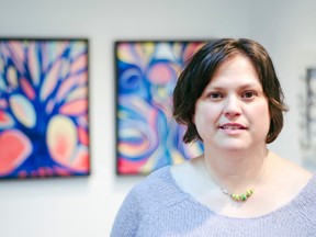 Brenda Isaak Takao stands in front of some of her paintings during the opening of her exhibit 'Organic' on January 24, 2015. The artist's show also predominantly features metal sculptures. John Stoesser photo/QMI Agency.