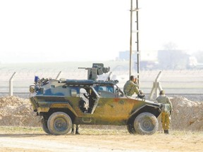 Turkish soldiers monitor the frontier Thursday near the Akcakale border crossing in Sanliurfa province, southeastern Turkey, where Islamic State militants control the Syrian side of the gate. But don?t expect anti-ISIS coalition member Turkey to seal the Syrian border, Gwynne Dyer says, because they don?t really want to. (Osman Orsal, Reuters)