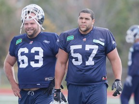 #63 Kyle Koch & #57 Tyler Holmes, under the watchful eye of head coach Scott Milanovich, as the Toronto Argonauts prepare for a game against Winnipeg last season. Stan Behal/QMI Agency