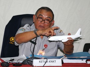 Tatang Kurniadi, chief of the National Transportation Safety Committee (NTSC),  holds a model plane during a news conference in Jakarta January 29, 2015. (REUTERS/Darren Whiteside)