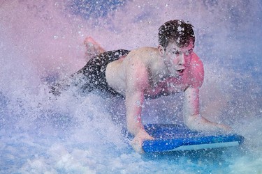 Lifeguard Jack Harris, 19,  rides the Tsunami FlowRider at West Edmonton Mall, in Edmonton Alta., on Friday Jan. 30, 2015. High volume pumps move 64,000 litres of water at 30 miles an hour to create a continuous sheet of flowing water, at the newly opened simulated surfing attraction. David Bloom/Edmonton Sun/QMI Agency