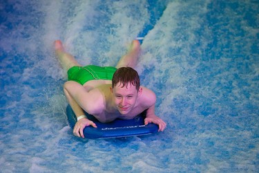 Tyler Wall, 17, rides the Tsunami FlowRider at West Edmonton Mall, in Edmonton Alta., on Friday Jan. 30, 2015. High volume pumps move 64,000 litres of water at 30 miles an hour to create a continuous sheet of flowing water, at the newly opened simulated surfing attraction. David Bloom/Edmonton Sun/QMI Agency