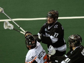 The Edmonton Rush's Robert Church (17) and Cory Conway (91) battle the New England Black Wolves' Ryan Hotaling (20) during first half NLL action at Rexall Place on Friday. (David Bloom/Edmonton Sun)