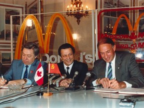 Moscow Minister Vladimir Malyshkov, left, and McDonald's Canada CEO George Cohonsign the deal as Deputy Mayor Valery Zharov, centre, looks on in this 1990 photo. (Toronto Sun files)