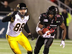 Ottawa RedBlacks Roy Finch eludes Giovanni Aprile of the Hamilton Tiger-Cats during CFL football action at TD Place in Ottawa on Friday October 31, 2014. Errol McGihon/Ottawa Sun/QMI Agency