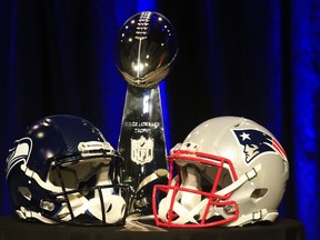 The Vince Lombardi Trophy is displayed between the helmets of the Seattle Seahawks (L) and New England Patriots prior to a joint press conference with Head Coach Bill Belichick of the New England Patriots and Head Coach Pete Carroll of the Seattle Seahawks prior to the upcoming Super Bowl XLIX on January 30, 2015 in Phoenix, Arizona.   (Rob Carr/Getty Images/AFP)