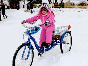 Gabrielle Kinnear, 9, of Cherry Valley enjoys a spin around the Mill Pond on a three-wheeled bike on Saturday during the Milford Winter Carnival.