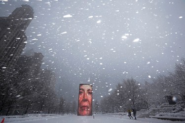 Two men walk past the Crown Fountain in blizzard conditions in Chicago, Illinois February 1, 2015. (REUTERS/Jim Young)