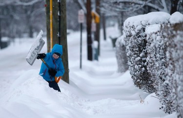 A young boy shovels snow along Broadway in the New York City suburb of Nyack, New York, February 2, 2015. The northeastern United States braced for the second major snow storm in a week on Monday after a huge winter system dumped more than a foot (30 cm) of snow in the Chicago area, closing schools from the Midwest to New England.  (REUTERS/Mike Segar)