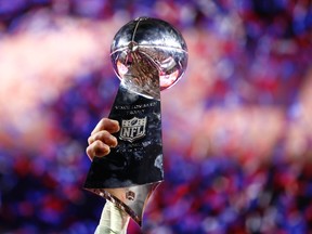 A member of the New England Patriots hoists the Vince Lombardi Trophy after defeating the Seattle Seahawks in Super Bowl XLIX at University of Phoenix Stadium. (Mark J. Rebilas-USA TODAY Sports)