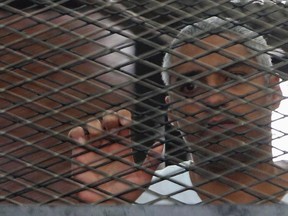 Al Jazeera journalist Mohamed Fahmy stands behind bars at a court in Cairo in this May 15, 2014 file photo. (REUTERS/Stringer/Files)