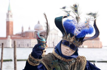 A masked reveller poses in front of St. Mark's square during the first day of carnival, in Venice February 1, 2015. REUTERS/Stefano Rellandini