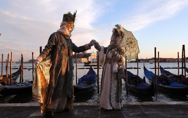 Masked revellers pose in front of St. Mark's square during the first day of carnival, in Venice February 1, 2015. REUTERS/Stefano Rellandini